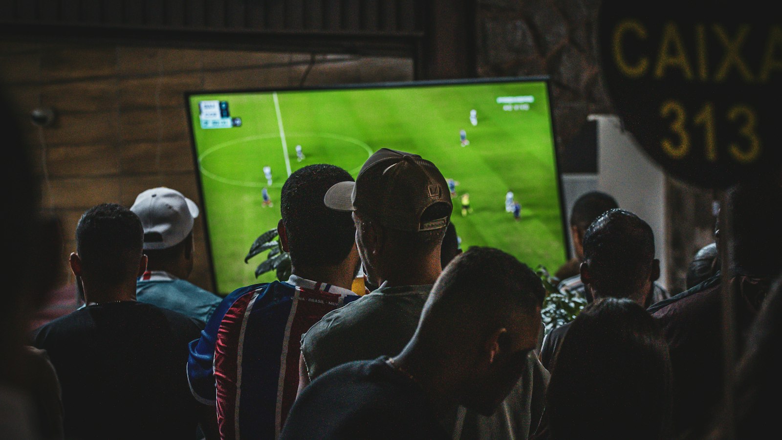 Groep vrienden kijkt voetbal op tv