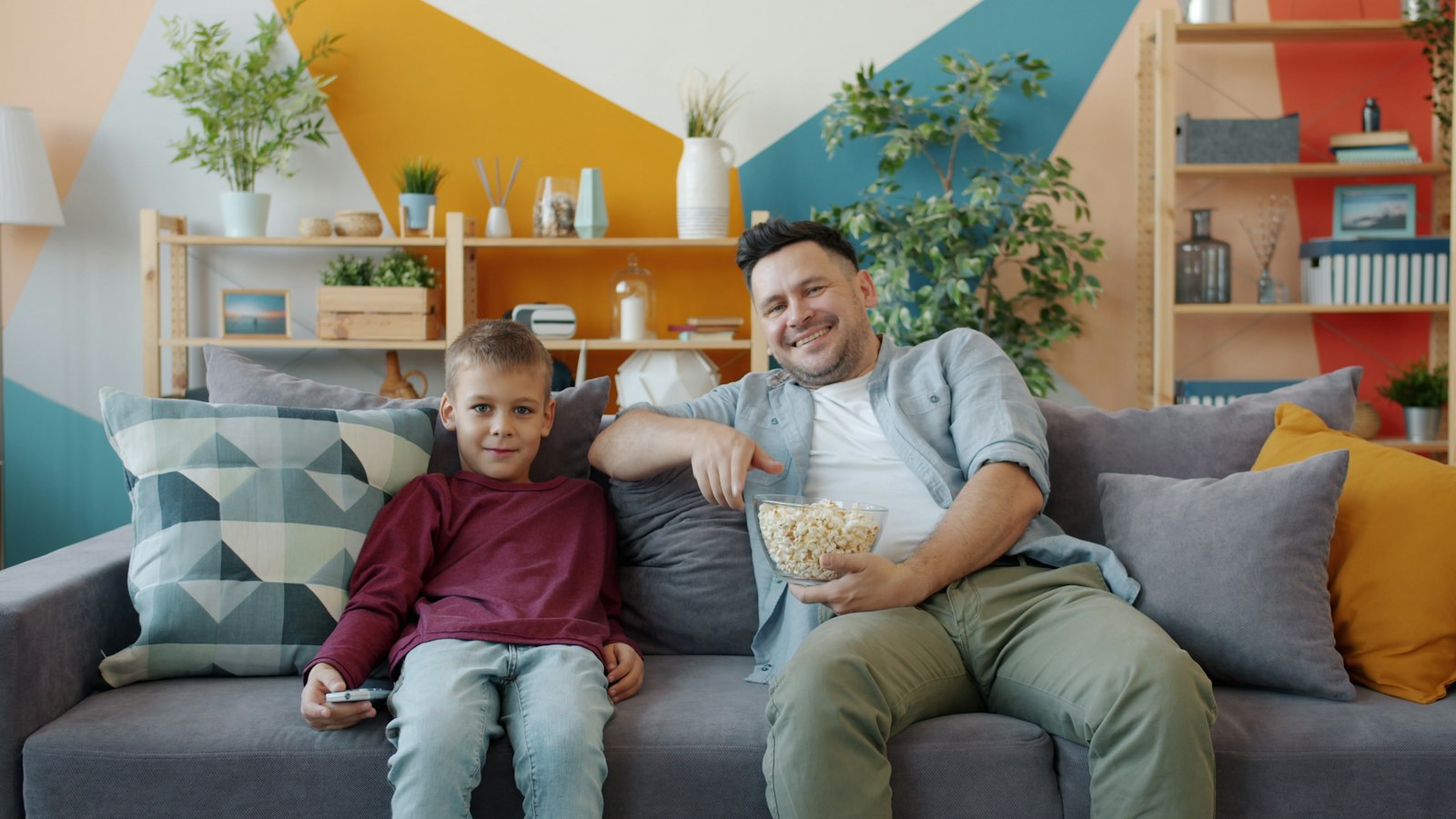 Padre e hijo viendo la tele con palomitas