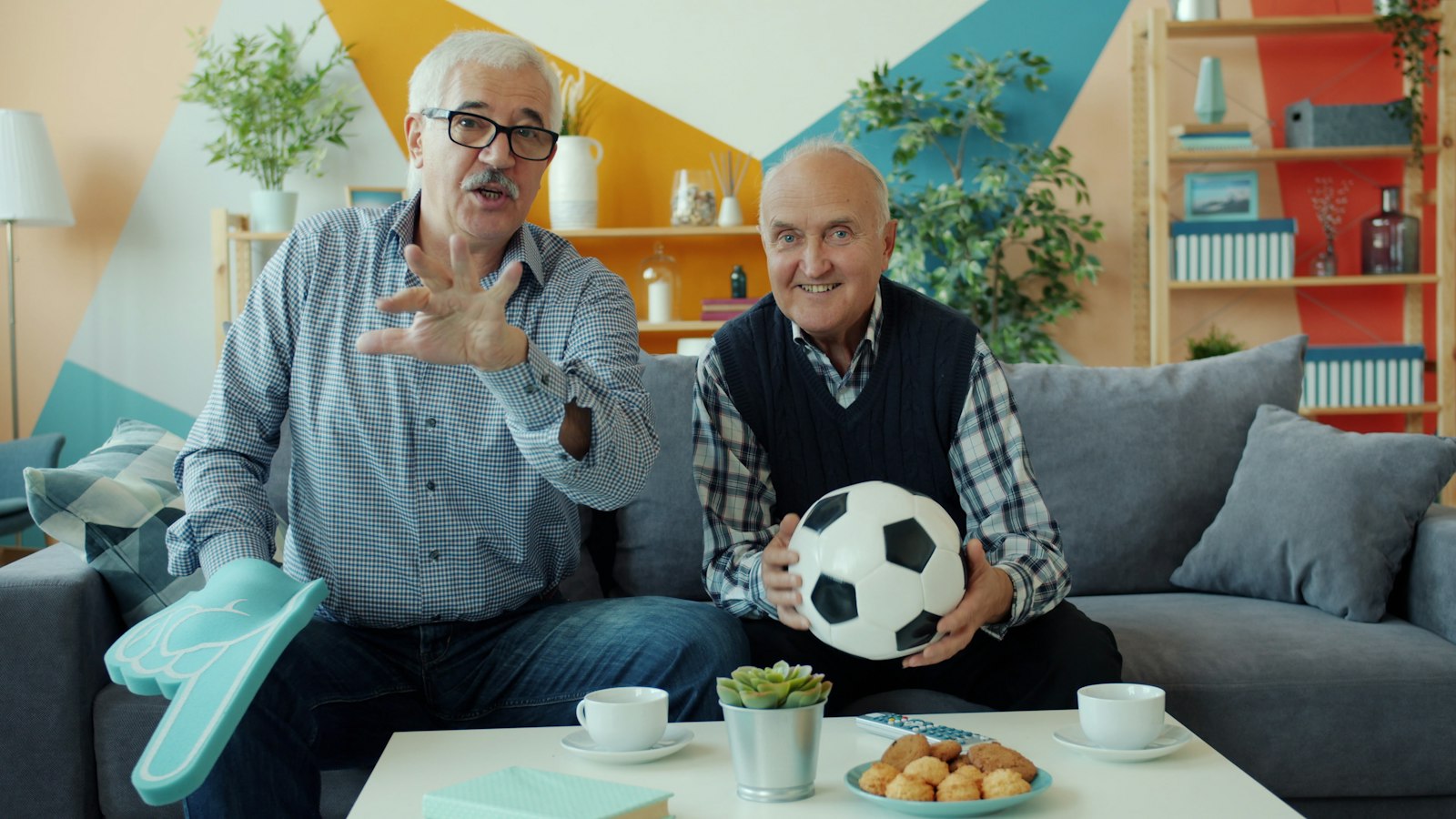 Dos hombres viendo fútbol en la televisión